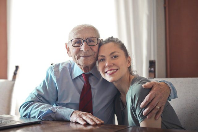 elderly man hugging a young lady