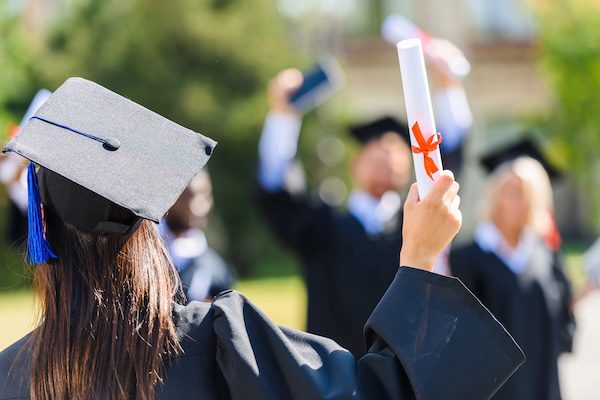 students holding diplomas after graduating